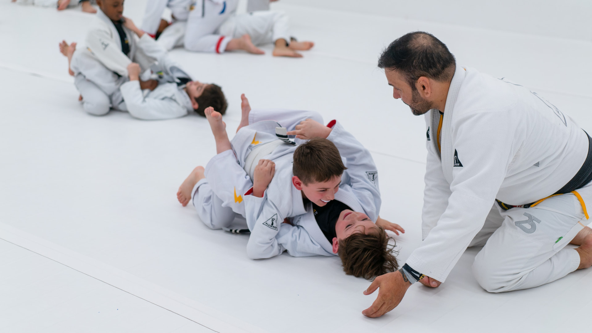 Coach guiding two kids during live training