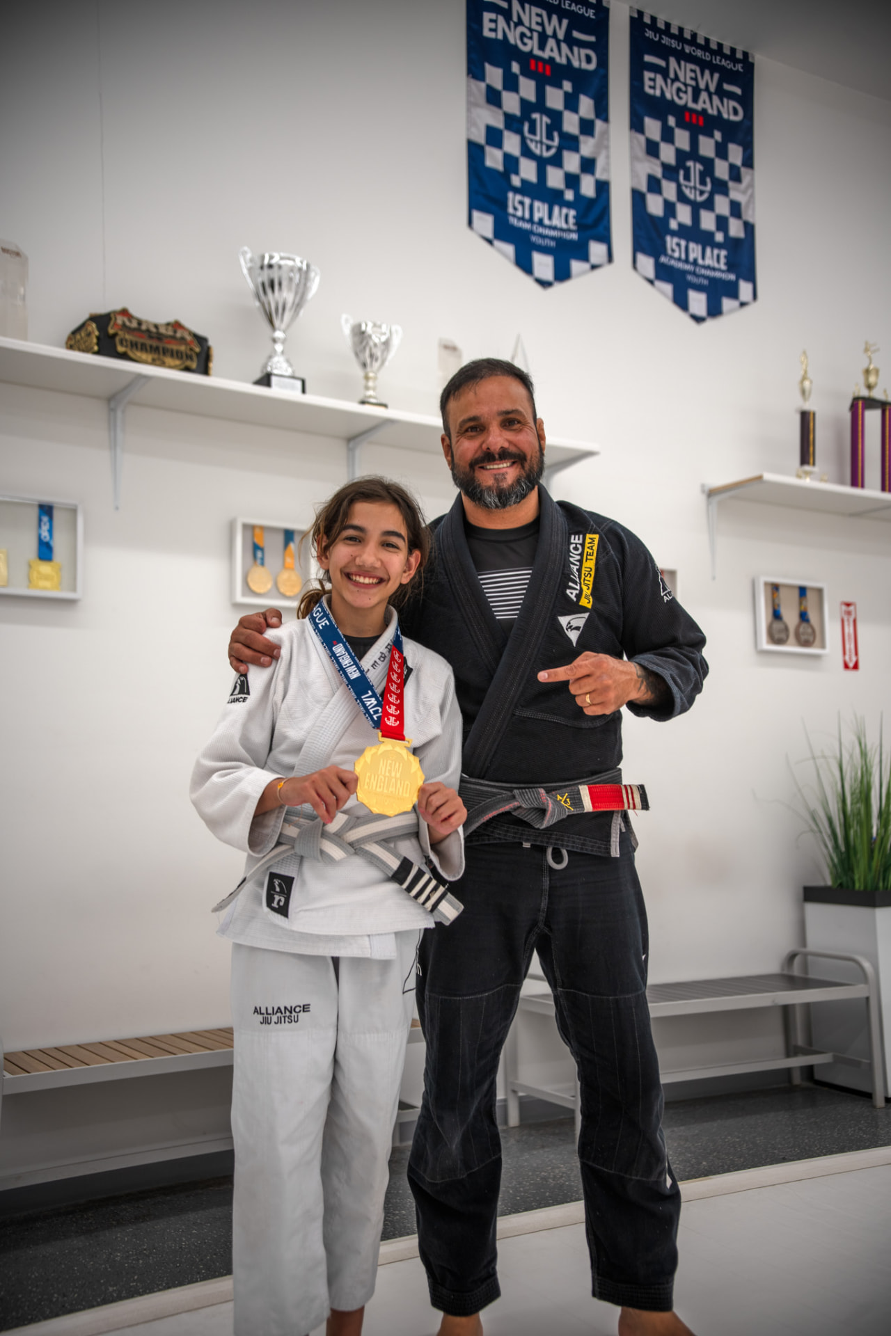 Professor and young student holding a New England gold medal