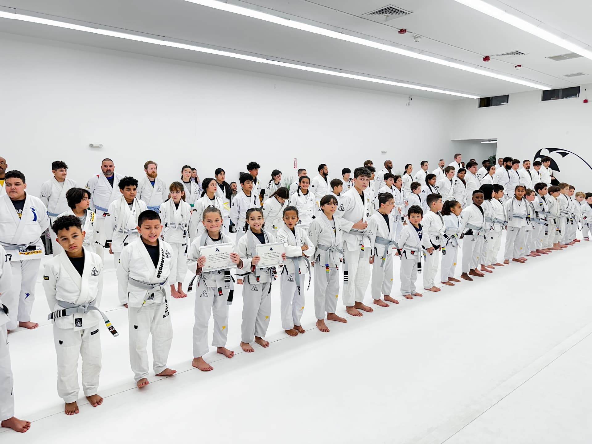 Large group of Alliance students lined up on the white mats